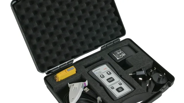 Portable test kit in a foam-lined case containing a handheld tester, cables, adapters and accessories.