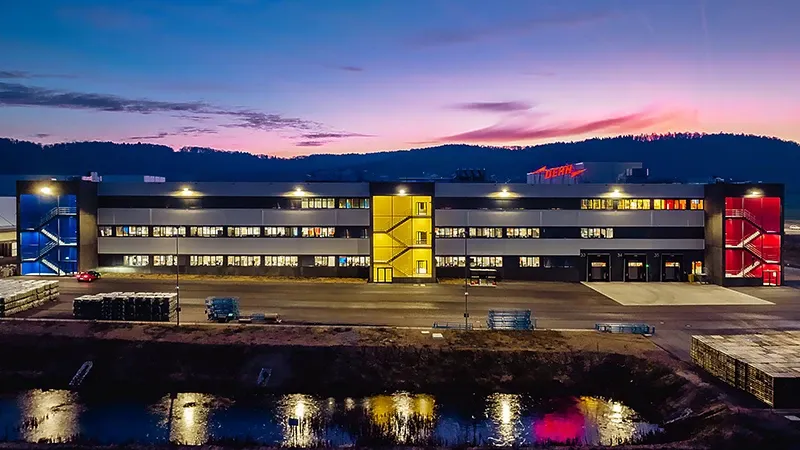 Industriegebäude bei Dämmerung mit Spiegelung im Wasser.