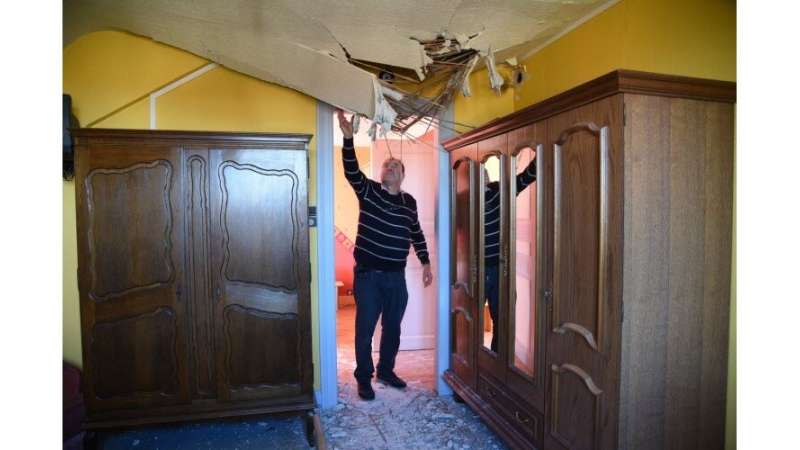 Photo de l'intérieur d'une maison alsacienne touchés par la foudre, le propriétaire montre que le plafond s'est effondré sous l'effet du choc, issu du journal DNA