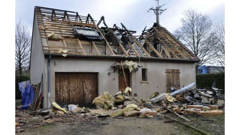 Photo d'une maison détruite par un impact direct de foudre, la charpente du toit est visible, les tuiles sont au sol et la maison présente des traces de feu, issu du journal le bien public