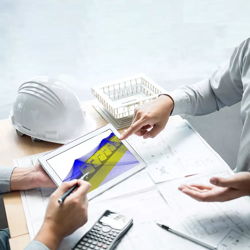 A desk covered with technical documents and a tablet. Fingers pointing to them.