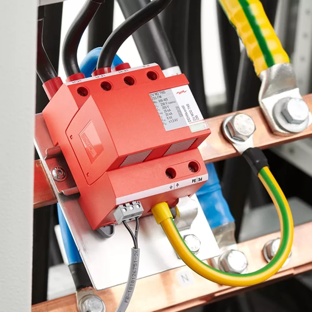 Parafoudre rouge, monté et câblé, dans une armoire de distribution secondaire.