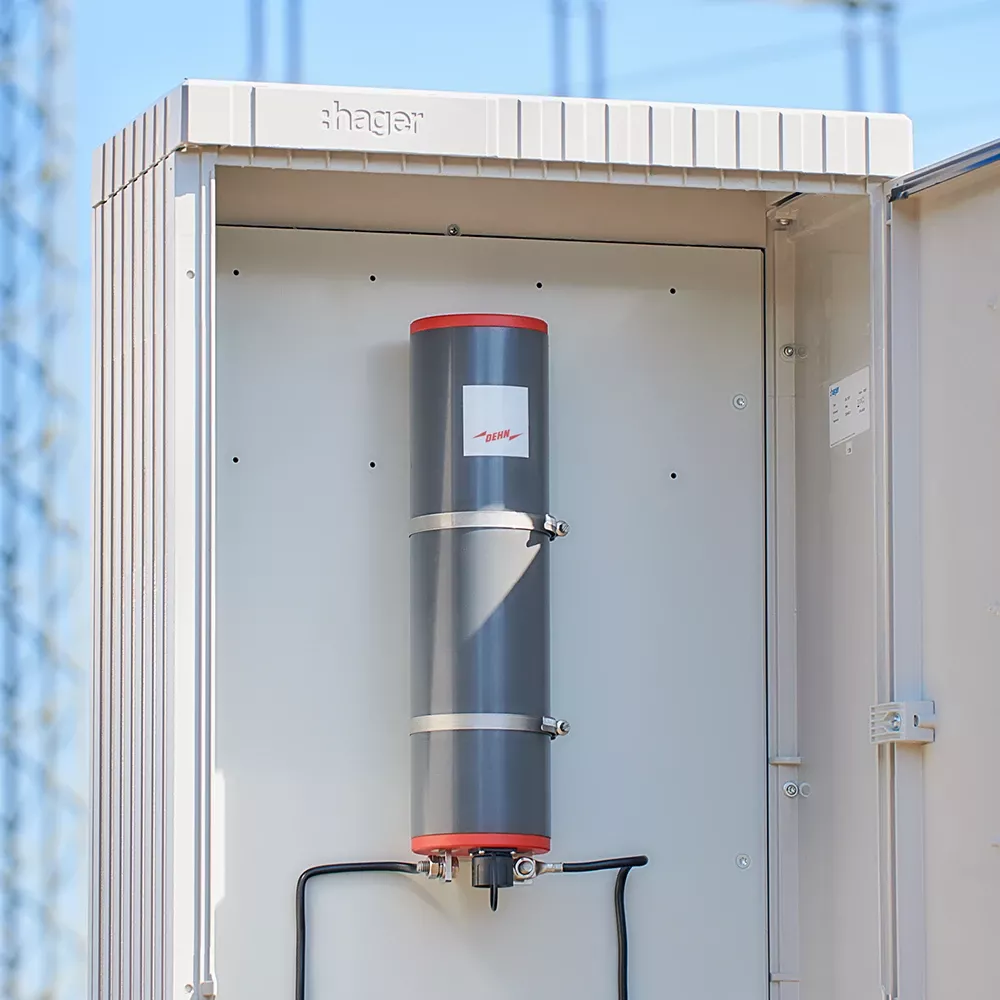 Open electrical cabinet with a grey cylindrical DEHN surge device mounted inside.