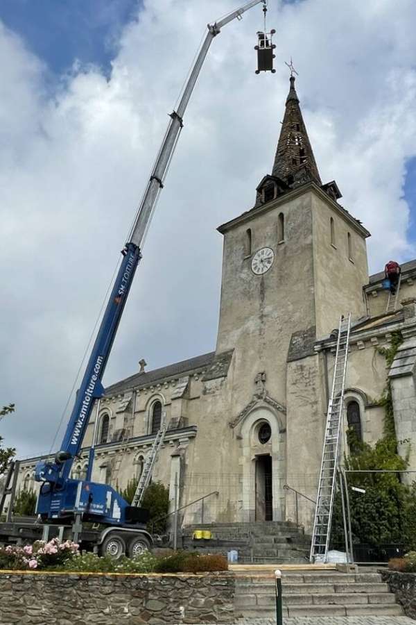 Image d'une église face à une grue, le clocher a brûlé suite à un impact de foudre direct sur la pointe du clocher, des équipes techniques de maintenance sont mobilisées face au bâtiments pour limiter les dégâts,issu du journal Ouest France
