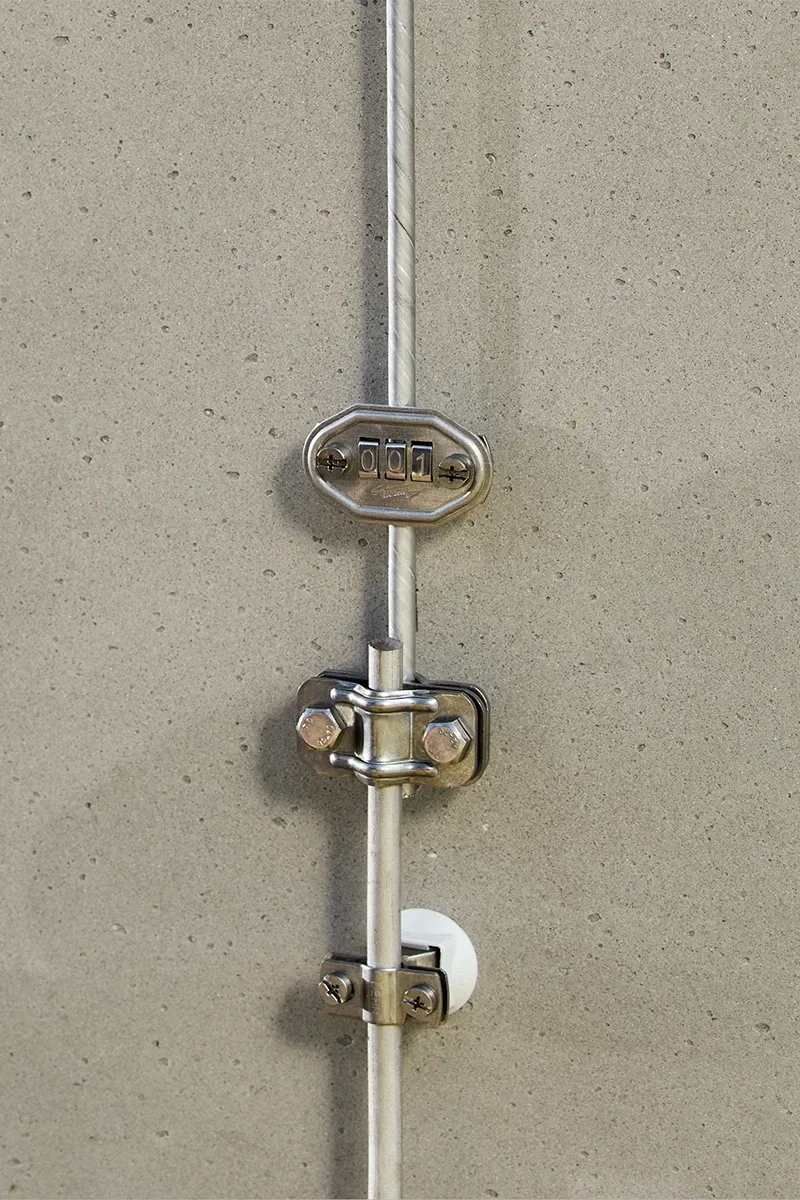 Dérivation composée d’un conducteur rond et de bornes, le tout monté sur un mur en béton.